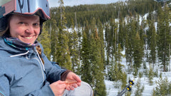 Photo of a woman on a ski lift using her Copper Rescue germ wand to clean her hands